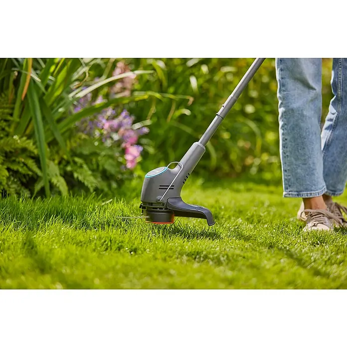 Gardena Power for All 18V Akku-Rasentrimmer EasyTrim 25/18V - 18 V, 2 Ah, Li-Ionen, 1 Akku, Schnittbreite Faden: 25 cm - Nahaufnahme eines Rasentrimmers, der von einer Person im Garten benutzt wird, mit Fokus auf das Gerät.