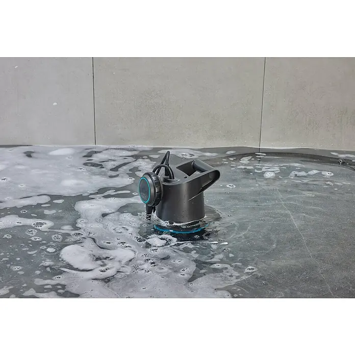 Gardena Schmutzwasserpumpe 20000 Basic - 550 W, Max. Fördermenge: 20.000 l/h, Eintauchtiefe: 7 m - Eine Gardena Schmutzwasserpumpe liegt in einer mit Schaum bedeckten Wanne, ideal zum Auspumpen von Becken oder zum Reinigen von Wasserflächen.
