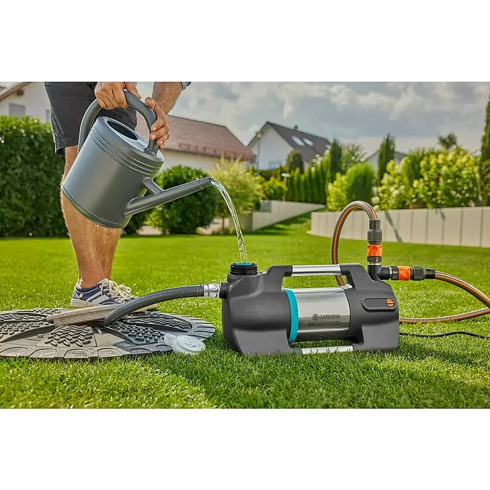 Gardena Sauggarnitur 25 mm 1" 7 m - Durchmesser: 25 mm, Länge: 7 m - Eine Gießkanne wird benutzt, um eine GARDENA Gartenpumpe 6300 SilentComfort zu befüllen, die auf einem Rasen steht.