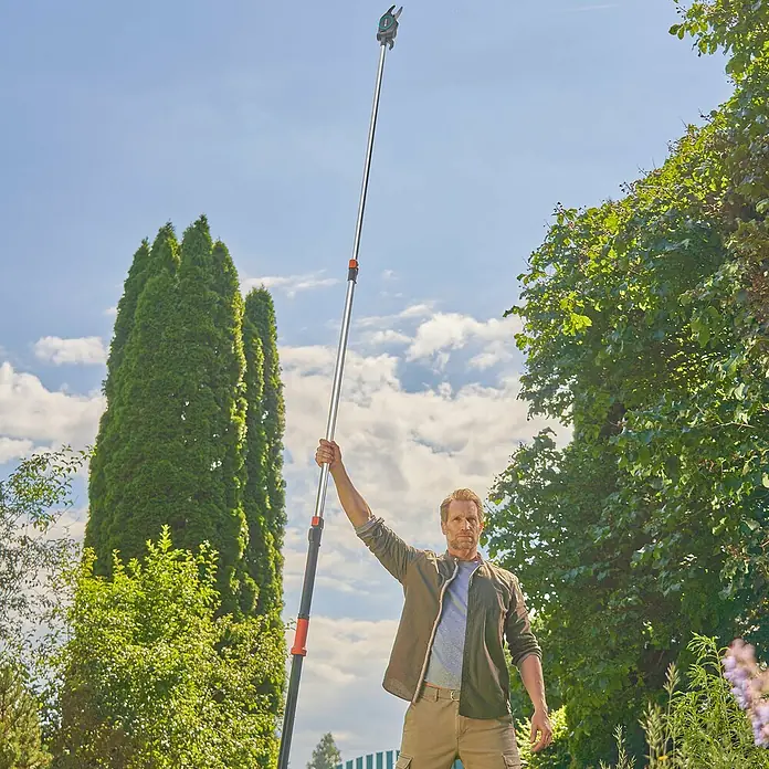 Gardena StarCut Teleskop-Astschere Pro L - Max. Aststärke: 32 mm - Ein Mann benutzt eine GARDENA Astschere mit Stiel, um Äste zu schneiden. Das Werkzeug ist für hohe Bäume konzipiert.