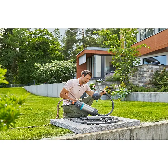 Gardena Rückflussverhinderer - Passend für: Saugschlauch-Durchmesser: 19 mm (3/4") / 25 mm (1") - Ein Mann arbeitet mit einer GARDENA Regenfasspumpe auf einem Rasen. Ideal für die Gartenbewässerung, sie ist effizient und einfach zu bedienen.
