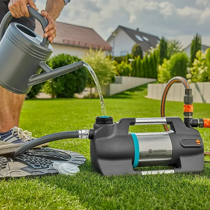 Gardena Sauggarnitur 25 mm 1" 4 m - Durchmesser: 25 mm, Länge: 4 m - Bewässerung mit der GARDENA 6300 SilentComfort Gartenpumpe: Gießkanne füllt Pumpe auf Rasen.