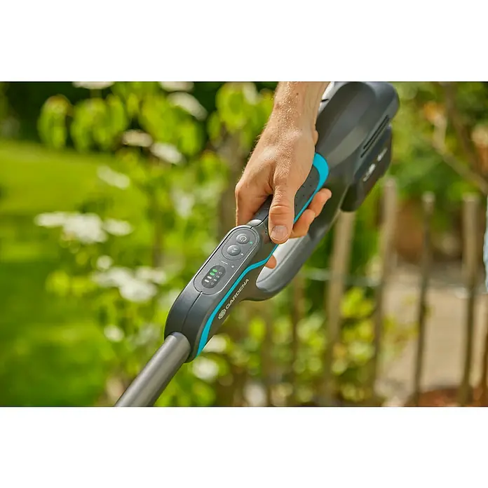 Gardena Power for All 18V Akku-Rasentrimmer PowerTrim 30/18V - 18 V, Li-Ionen, Ohne Akku, Schnittbreite Faden: 30 cm - Nahaufnahme einer Gardena Akku-Grasschere, die von einer Hand gehalten wird, mit Fokus auf Bedienelemente und Akkuanzeige.