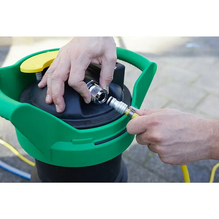 Unger HydroPower Ultra Reinigungs-Set DI Einsteigerset Alu - 6 -tlg. - Das Bild zeigt eine Person, die einen gelben Schlauch an einen Gartengeräte-Anschluss mit grünen Akzenten befestigt.
