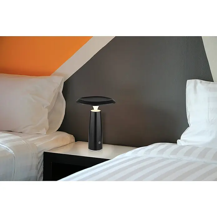 Globo Akku-Tischleuchte Bowie - Schwarz, Höhe: 20 cm - Elegante schwarze Tischleuchte mit modernem Design, platziert auf einem Nachttisch zwischen zwei Betten in einem stilvollen Schlafzimmer.