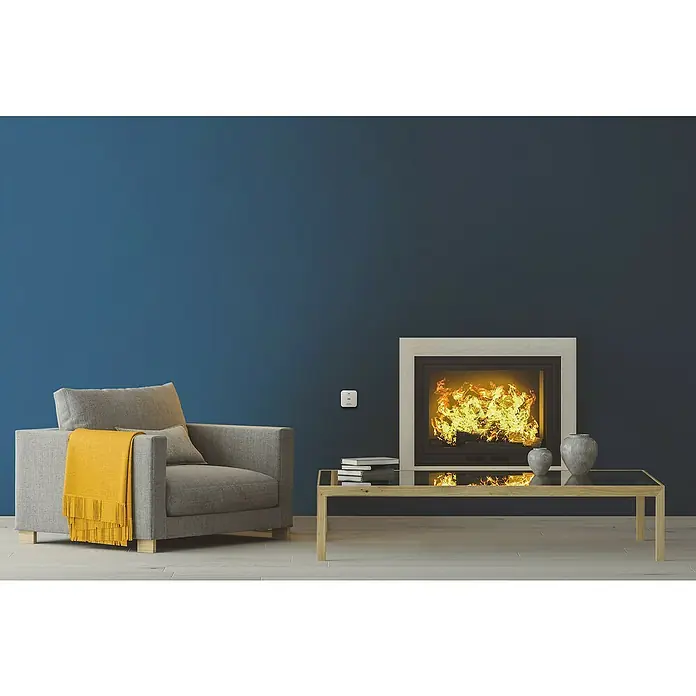 Ledvance Smart+ WiFi Kohlenmonoxidmelder - L x B x H: 8,5 x 2,73 x 8,5 cm, Batterielaufzeit: 5 Jahre - Ein gemütliches Wohnzimmer mit einem modernen Kamin, einem grauen Sessel mit gelber Decke und einem stilvollen Couchtisch mit Vasen.