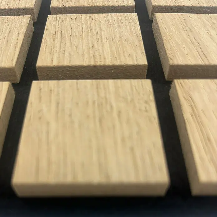 acous Akustikpaneelmuster Blockbuster - 150 x 150 x 10,3 mm, Eiche Hellbraun - Nahaufnahme von quadratischen Akustikplatten aus Holz, die für eine verbesserte Klangqualität in Räumen sorgen. Ihre natürliche Maserung ist sichtbar.