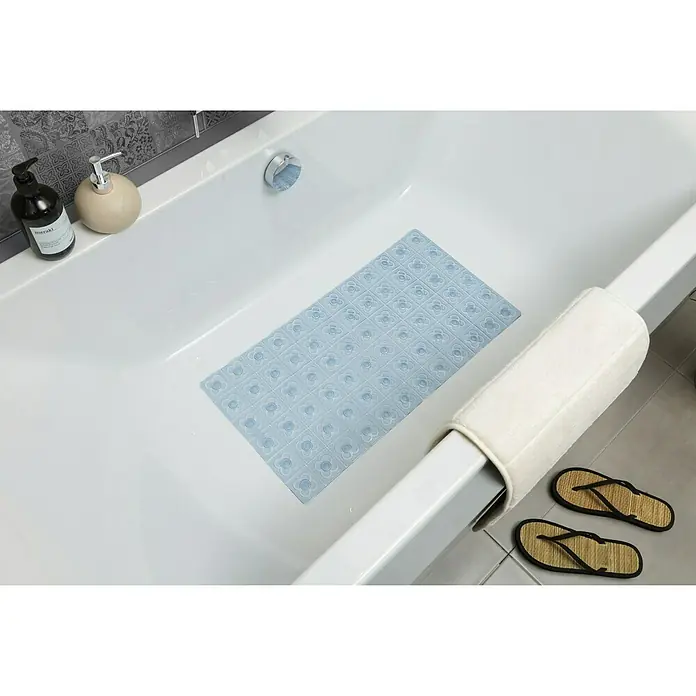 Tatay Alfombra antideslizante para ducha BCN - 36 x 72 cm, PVC, Azul - Un producto de alfombra de baño rectangular azul claro con un patrón de flores se encuentra dentro de una bañera blanca con productos de higiene.