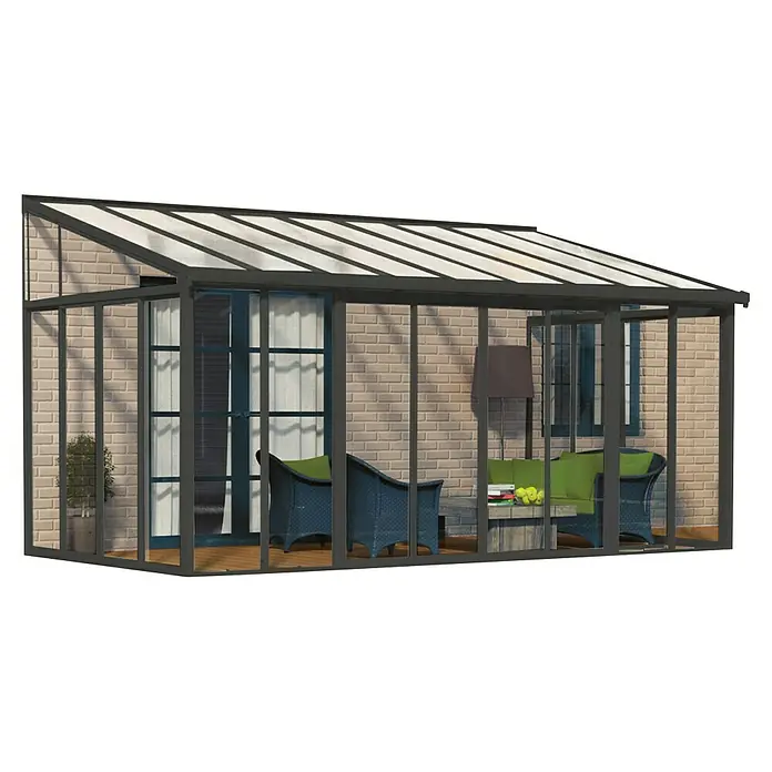 Palram – Canopia Wintergarten San Remo - B x T x H: 5,46 x 3 x 3,1 m, Anthrazitgrau - Nahaufnahme eines Wintergartens mit Möbeln und Pflanzen, der an ein Haus angebaut ist. Der Wintergarten hat ein transparentes Dach.