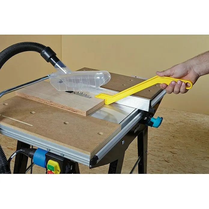 Wolfcraft Master Cut Banco de trabajo 1500 - Altura de trabajo: 865 mm, Carga soportada: 200 kg, Negro - Una sierra de mesa Wolfcraft en acción, cortando un trozo de madera mientras una mano sostiene una herramienta amarilla.