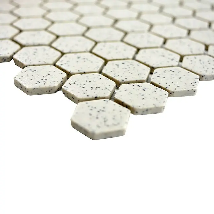 Mosaikfliese Hexagon Uni CU HX208S - 26 x 30 cm, Cremeweiß, Matt - Nahaufnahme von sechseckigen Mosaikfliesen mit gesprenkeltem Muster, ideal für stilvolle Wand- und Bodengestaltungen.