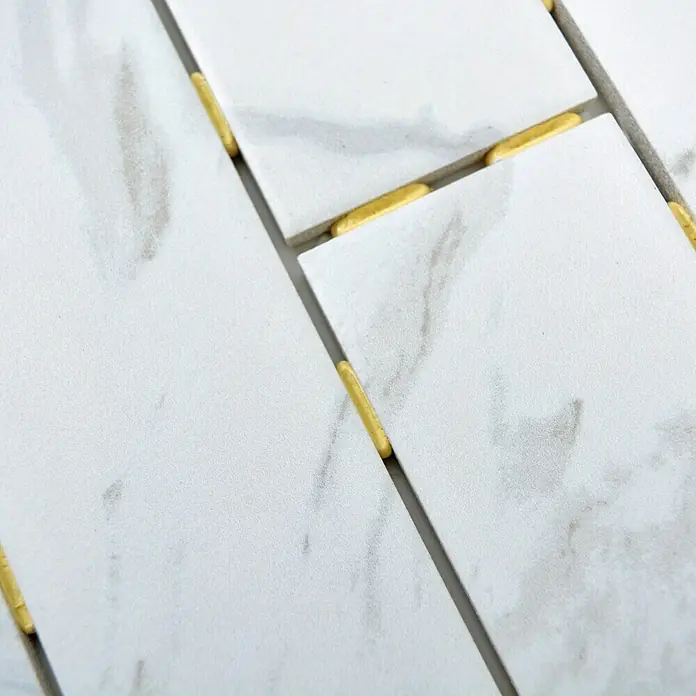 Mosaikfliese Brick CDJ 01BR - 25,2 x 36,7 cm, Weiß, Matt - Nahaufnahme von weißen Marmorfliesen mit goldenen Abstandshaltern, die ein luxuriöses und modernes Designelement zeigen.