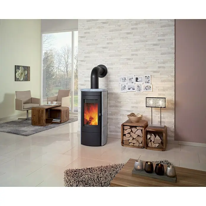 Hark Kaminofen Tiamo Ex - 6 kW, Raumheizvermögen: 165 m³, Material Verkleidung: Stahl, Grau - Ein moderner Kaminofen in einem stilvollen Wohnzimmer mit hellen Möbeln und Akzenten. Der Ofen strahlt Wärme und Gemütlichkeit aus.