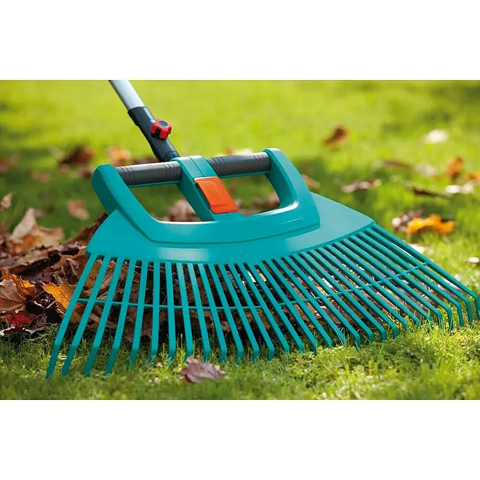 Gardena Combisystem Laubbesen XXL Vario - Ohne Stiel - Nahaufnahme eines türkisfarbenen Gardena-Rechens auf einem Rasen mit Blättern, der zum Zusammenkehren von Gartenabfällen verwendet wird.