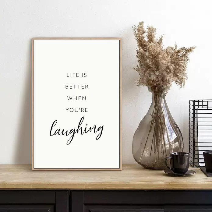 Reinders Bild Slim Frame Wood - Laughing, B x H: 20 x 30 cm - Ein Poster mit Naturholzrahmen, das den Spruch "LIFE IS BETTER WHEN YOU'RE laughing" in schwarzem Text zeigt, auf einer Holzoberfläche.