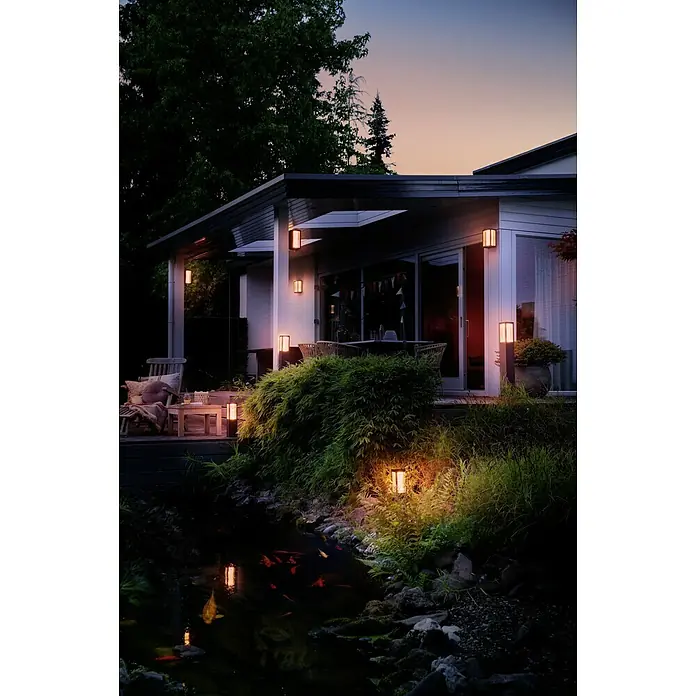 Philips Hue LED-Außenwandleuchte Impress - 8 W, 11,7 x 19 x 24 cm, Schwarz, IP44 - Außenaufnahme eines Hauses mit rechteckigen Außenleuchten, die ein warmes Licht verbreiten und eine angenehme Atmosphäre schaffen.