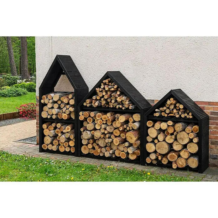 Kaminholzregal Dione III - 90 x 35 x 120 cm, Holz, Schwarz - Drei dunkle Holzregale in Hausform, gefüllt mit Brennholz, stehen vor einer Wand und bieten stilvolle Lagerung für das Kaminholz.