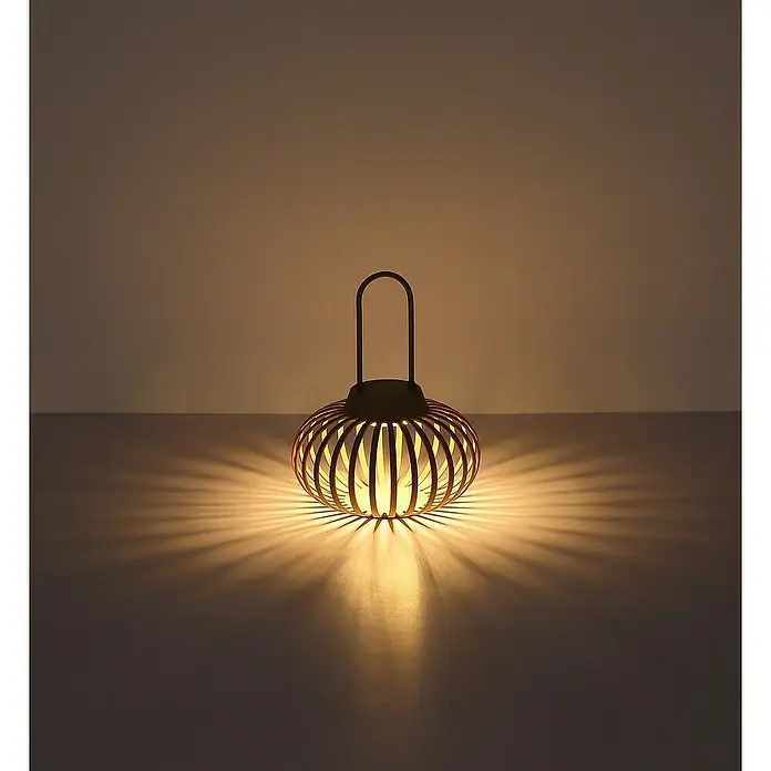 Globo Akku-Tischleuchte - Sandfarben, Warmweiß, Ø x H: 20,5 x 25,5 cm - Nahaufnahme einer dekorativen goldenen Laterne, die ein warmes, stimmungsvolles Licht ausstrahlt und interessante Schatten erzeugt.