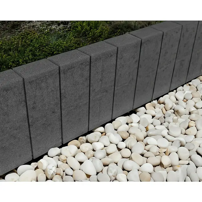 EHL Palisade Bord Lima - 6 x 50 x 25 cm, Anthrazit, Beton - Eine Reihe von grauen Bordsteinen, die einen Gartenweg säumen. Die weißen Kieselsteine bilden einen schönen Kontrast zum Grau des Betons.