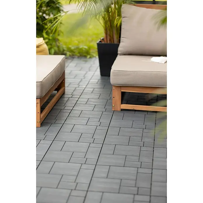 Klickfliese Mosaik - Kunststoff, 30 x 30 x 1,5 cm, Stahlgrau, 6 Stk. - Terrassenfliesen aus grauem Kunststoff mit Klickverschluss verlegt auf einer Terrasse mit Möbeln aus Holz und beigen Polstern.