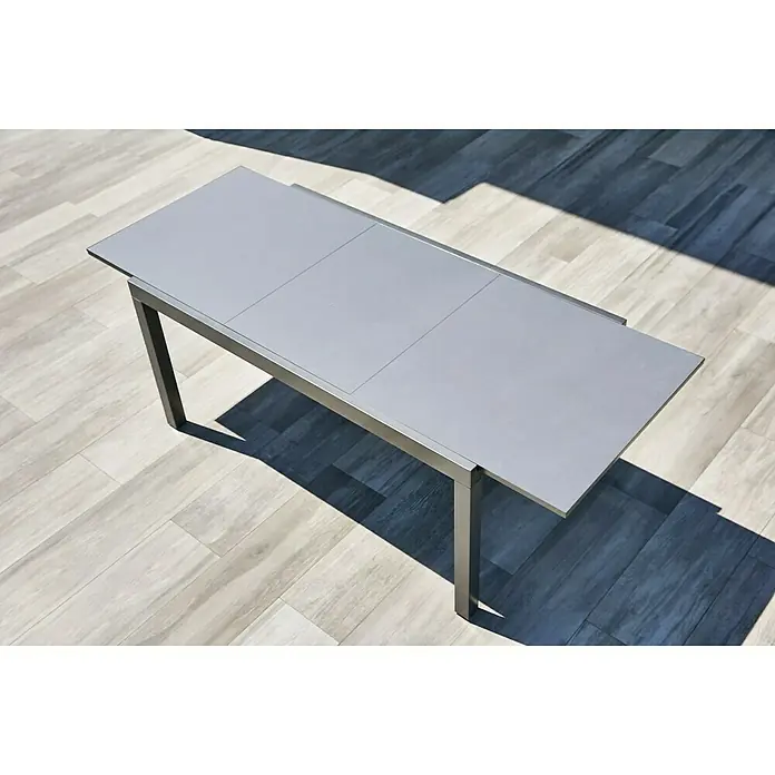 Gartenmöbel-Set Maja/Carina - 7 -tlg., Glas/Aluminium/Akazie, Anthrazit/Naturbraun, Tischplatte ausziehbar - Elegantes, ausziehbares Gartentisch-Design mit einer glatten, grauen Tischplatte und einem minimalistischen Metallgestell für den Außenbereich.