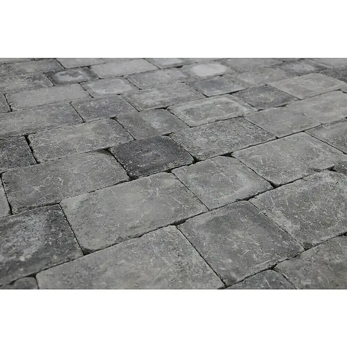 Pflasterstein Times - Anthrazit, 20 x 30 x 7 cm, Rechteckig - Nahaufnahme eines Pflasterwegs, der aus grauen Steinen besteht. Die Steine sind rechteckig und unregelmäßig verlegt, was dem Weg ein rustikales Aussehen verleiht.