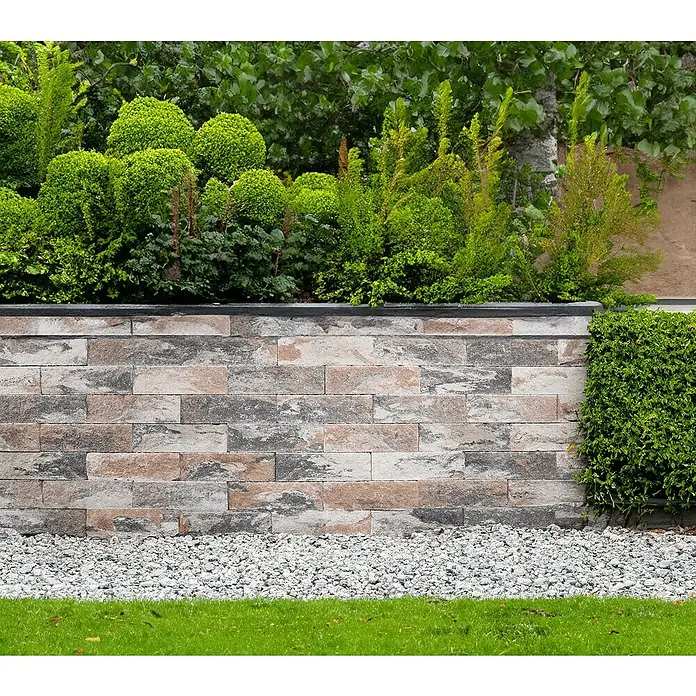 EHL Mauerstein Anzio Light - 25 x 18 x 15 cm, Muschelkalk, Beton - Graue und braune Steinmauer mit Pflanzen und Kies, die eine rustikale Gartengestaltung unterstreicht.