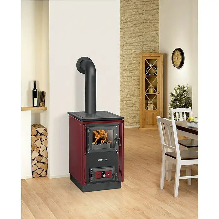 Justus Küchenherd Rustico-50 2.0 - 7 kW, Raumheizvermögen: 144 m³, Bordeaux - Ein Justus Kaminofen in Rot und Schwarz mit einem schwarzen Rauchrohranschluss in einem hellen Wohnzimmer.