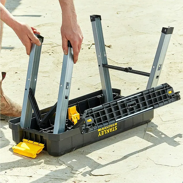 Stanley FatMax Werkzeugkasten FMST81083-1 - L x B x H: 29,6 x 64 x 28,7 cm, Klappbar - Stanley Fatmax Werkbank mit ausklappbaren Beinen wird von einer Person aufgebaut. Sie ist kompakt und einfach zu transportieren.