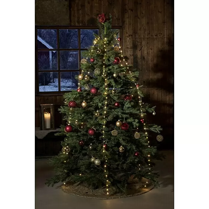 Konstsmide LED-Lichterkette Baummantel - Innen, Lichtfarbe: Bernstein, Anzahl Leuchtmittel: 180 Stk., Netzbetrieben - Geschmückter Weihnachtsbaum mit roten und goldenen Kugeln und warmen Lichterketten, der eine gemütliche Atmosphäre schafft.