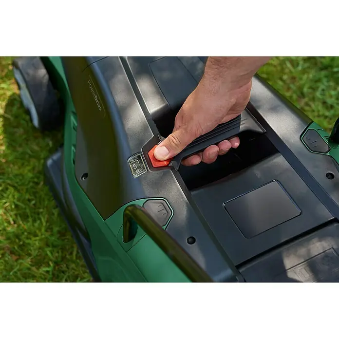 Bosch Elektro-Rasenmäher UniversalRotak 450 - Leistung: 1.300 W, Schnittbreite: 34 cm - Nahaufnahme eines grünen Bosch-Rasenmähers, der von einer Person bedient wird, mit Fokus auf den roten Startknopf.