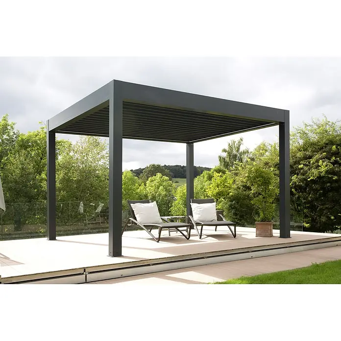 Wismar-NFI Pergola Bio - B x T: 341 x 400 cm, Grau/Grau, Aluminium - Eine moderne Pergola mit zwei Liegestühlen und Kissen auf einer Terrasse, umgeben von Bäumen und Grün.