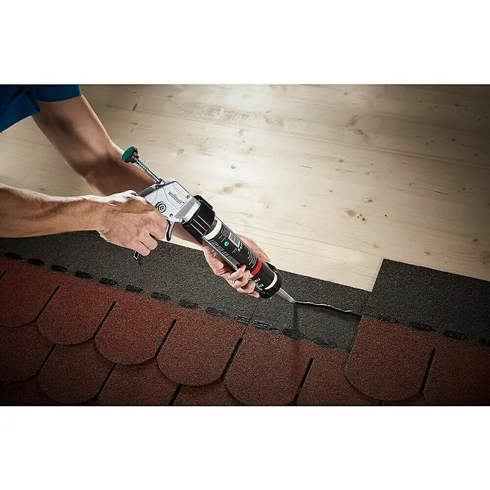 Wolfcraft Kartuschenpresse MG 611 - Geeignet für: Acryl - Ein Handwerker verwendet eine Wolfcraft Auspresspistole, um Bitumenschindeln auf einem Dach zu befestigen. Das Werkzeug ist ein Muss für Dacharbeiten.