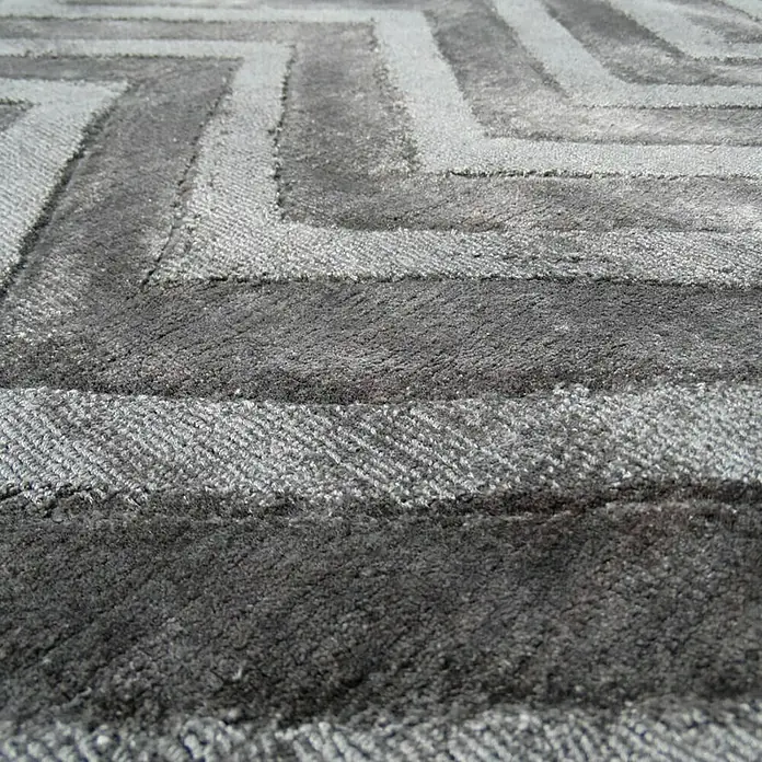 Kayoom Kurzflorteppich Luxury 410 - Grau, 170 x 120 cm, 100 % Viskose - Nahaufnahme eines modernen grauen Teppichs mit geometrischem Muster, der Textur und Design hervorhebt.