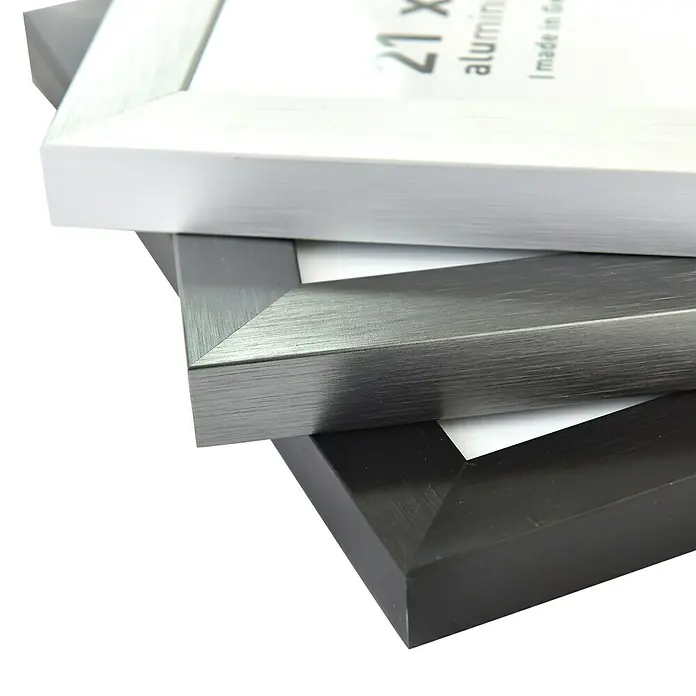 Accent Alurahmen StarDIN A4 / 21 x 29,7 cm, Silber - Nahaufnahme von drei Aluminium-Bilderrahmen in Weiß, Grau und Schwarz, die gestapelt sind und sich ideal für moderne Wohnkulturen eignen.