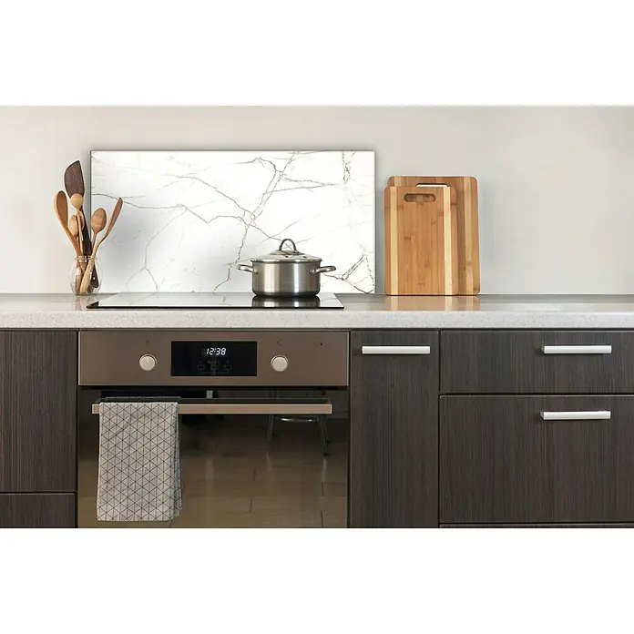 CUCINE Küchenrückwand - White Marble, 80 x 40 cm, Stärke: 6 mm, Einscheibensicherheitsglas (ESG) - Einbauherd mit Kochfeld, Edelstahltopf, Kochutensilien, Schneidebrettern und einem Geschirrtuch in einer modernen Küche.