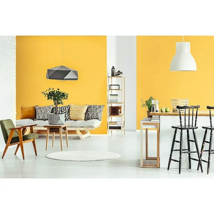 SCHÖNER WOHNEN-Farbe Wandfarbe Trendfarbe - Honey, Matt, 2,5 l, Konservierungsmittelfrei - Ein modernes Wohnzimmer mit einem grauen geometrischen Lampenschirm, der über einem stilvollen Sofa hängt. Helle Akzentwand in Gelb sorgt für Wärme.