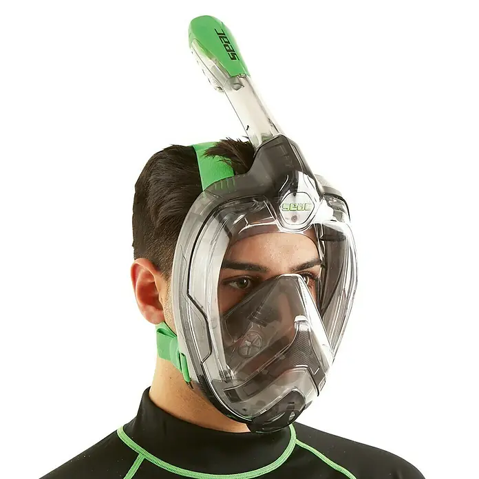Seac Sub Máscara de Snorkel Mágica - L/XL, Plástico, Negro/lima - Un hombre lleva una máscara de snorkel facial completa SEAC con detalles verdes, que ofrece una visión clara bajo el agua.