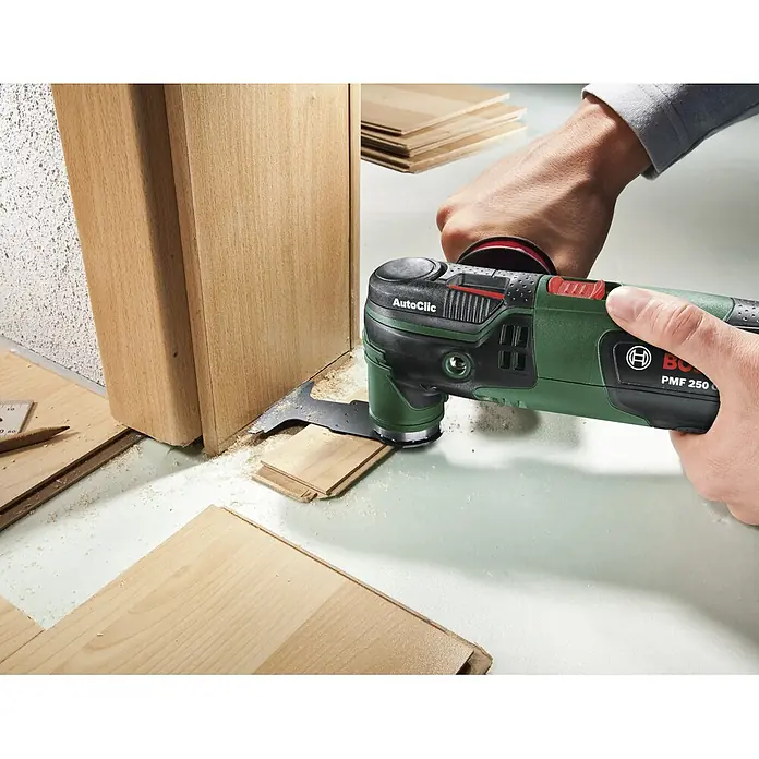 Bosch Multiherramienta PMF 250 CES - 250 W, Sistema STARLOCK - Primer plano de una multiherramienta Bosch PMF 250 cortando madera. La herramienta es verde y negra.