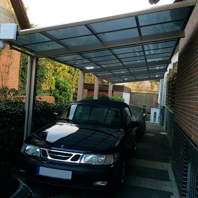Ximax Carport LINEA Tandem 80 - Außenmaß inkl. Dachüberstand (B x T): 2,73 x 9,83 m, Doppelcarport, Edelstahloptik, Schneelast: 100 kg/m² - Das Bild zeigt einen schwarzen Saab unter einem Carport mit Glasdach, der Schutz vor Witterungseinflüssen bietet. Die Konstruktion wirkt stabil und modern.
