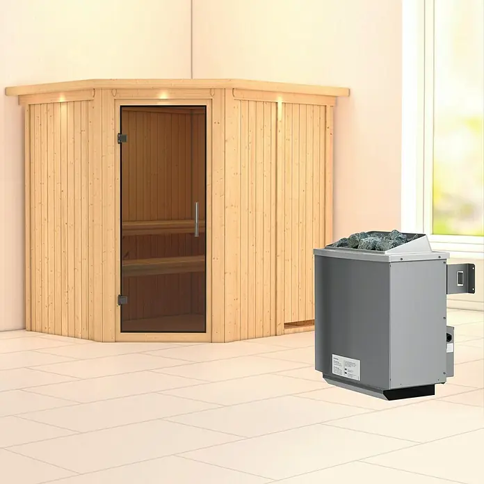 Karibu Elementsauna Siirin - Mit 9 kW Ofen mit integrierter Steuerung, Mit Dachkranz und Beleuchtung, Materialspezifizierung Tür: Ganzglas Graphit, L x B x H: 210 x 184 x 192 cm - Nahaufnahme einer Sauna mit Holztüren und einem grauen Saunaofen mit Steinen darauf in einem hellen Raum.