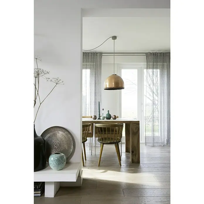 Rasch Home Schlaufenschal Charisma - 140 x 255 cm, 100 % Polyester, Grau - Ein Esszimmer mit einem Holztisch, Stühlen und einer goldenen Hängelampe über dem Tisch. Eine Anrichte mit Deko steht links.