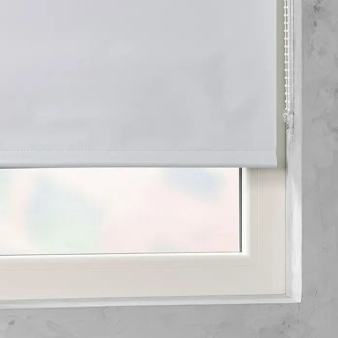 Rollo Basic - B x H: 60 x 175 cm, Weiß, Uni, Verdunkelnd - Nahaufnahme eines weißen Rollos am Fenster, das für Privatsphäre und Lichtsteuerung sorgt, während es elegant in das Fensterdesign integriert ist.
