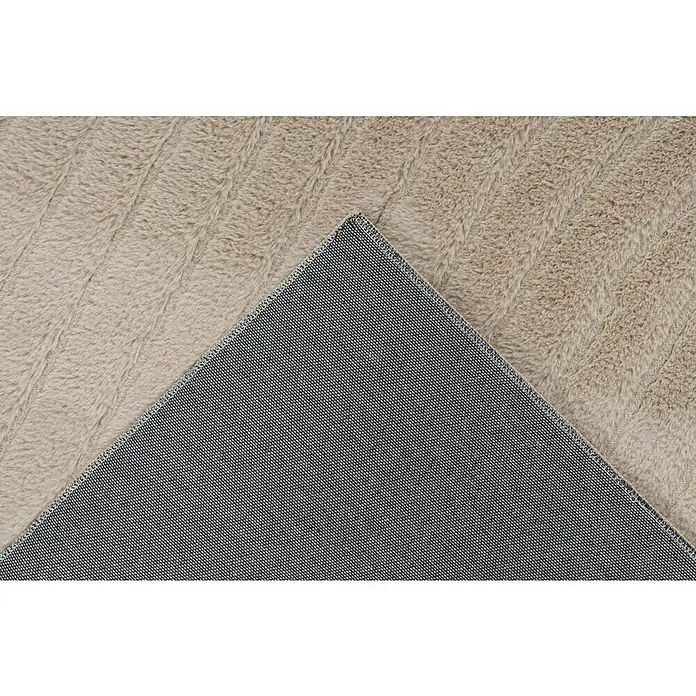 Fellteppich Zen - Beige, 150 x 80 cm, 100 % Polyester - Nahaufnahme eines beigefarbenen Zottelteppichs, der eine weiche Textur und eine robuste, gewebte Unterseite zeigt, ideal für Komfort und Haltbarkeit.