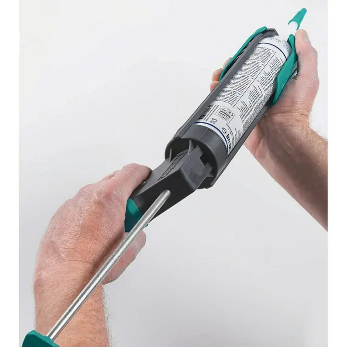 Wolfcraft Pistola de silicona MG 200 - Apto para: Silicona y cartuchos - Primer plano de una pistola de calafateo que sujeta un cartucho, sostenida por dos manos contra un fondo blanco.