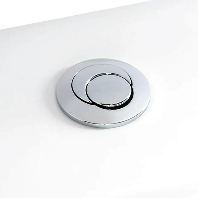 Roca Eos Pack de WC - Con borde de descarga, Salida dual, Blanco - Primer plano de un botón de descarga de inodoro redondo y brillante con un diseño de doble botón en un tanque de inodoro de cerámica blanca.