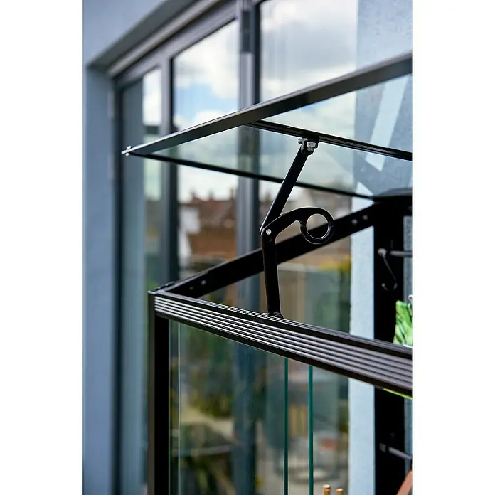 Juliana Gewächshaus - Außenmaß inkl. Dachüberstand (B x T): 80 x 40 cm, Material Seitenwand: Glas, 4 mm, Schwarz - Nahaufnahme eines Gewächshauses mit Glasfenstern und einem schwarzen Metallrahmen auf einem Balkon.