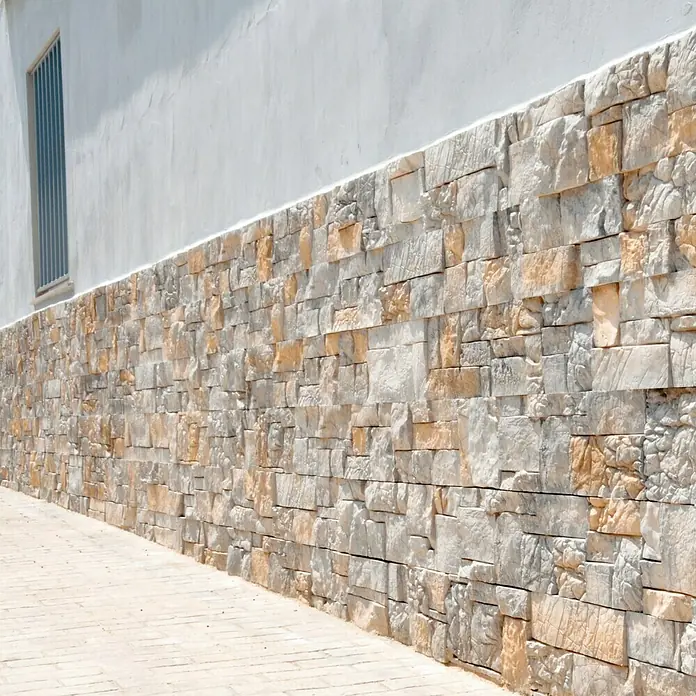 Revestimiento de piedra Alpes Pino - Cantidad total: 4 pzs. - Vista detallada de una pared de piedra en un edificio, destacable por su textura y color. Las piedras dan a la fachada un encanto rústico.