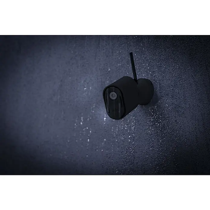 Abus Überwachungskamera Smartlook WLAN PPIC54520 BK - Auflösung: 4K Ultra HD/HDR, Schwarz - Eine schwarze Überwachungskamera mit Antenne ist an einer Wand befestigt und wird bei Regen von Wasser umspült, um Schutz zu bieten.