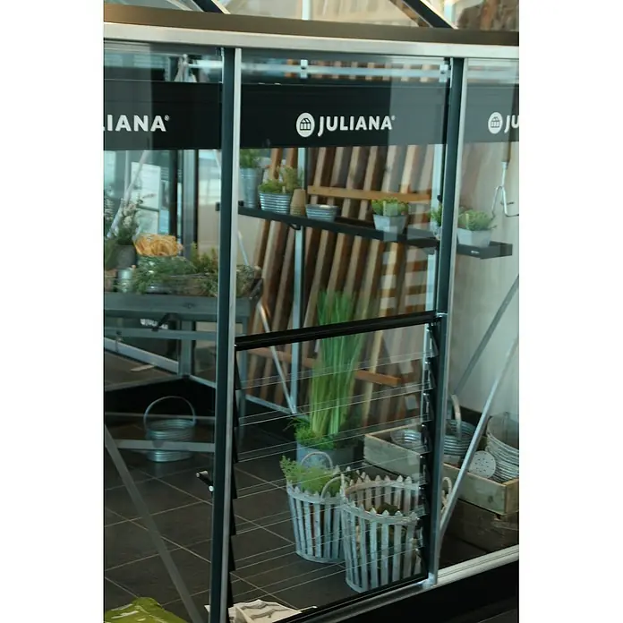 Juliana Gewächshaus-Lüfter - Passend für: Juliana Gewächshausserien Premium und Gärtner - Innenansicht eines Juliana Gewächshauses mit Regalen und Pflanzen, die das Produkt und seine Verwendungsmöglichkeiten hervorheben.